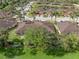 Aerial view of houses with brown roofs and lush green landscape at 4410 Turnberry Cir, North Port, FL 34288