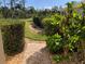 Landscaped backyard with brick pathway and lush greenery at 1251 Hot Springs Pt, Englewood, FL 34223