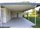 View from underneath carport showing concrete flooring and backyard at 1311 Lindsay Ave, Punta Gorda, FL 33982