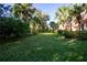 Mature trees and lush landscaping line a pathway at 19310 Water Oak Dr # 203, Port Charlotte, FL 33948
