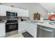 Bright kitchen with stainless steel appliances and white cabinets at 19310 Water Oak Dr # 203, Port Charlotte, FL 33948