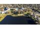 Aerial view showcasing a community with a lake, pool, tennis court, and residential buildings at 19310 Water Oak Dr # 203, Port Charlotte, FL 33948