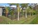 Lush backyard with tropical plants, a fence, and a glimpse of the pool at 2363 Homestead Cir, North Port, FL 34286