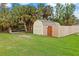 Scenic backyard with sheds, lush grass, and wooden fence, creating a serene outdoor space at 4290 Randypaar St, Port Charlotte, FL 33948