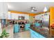 Kitchen with teal cabinets, granite island, and orange walls at 4290 Randypaar St, Port Charlotte, FL 33948