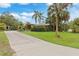 Landscaped front yard with palm trees and a long driveway leading to the house at 4290 Randypaar St, Port Charlotte, FL 33948