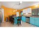 Kitchen featuring turquoise blue lower cabinets, white upper cabinets, and a breakfast bar at 4290 Randypaar St, Port Charlotte, FL 33948