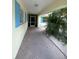 View of a walkway with blue shuttered windows and bright yellow exterior at 4290 Randypaar St, Port Charlotte, FL 33948