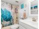 Clean bathroom with white vanity, tub shower, and beachy decor at 4290 Randypaar St, Port Charlotte, FL 33948