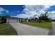 Front view of the house with driveway and landscaping at 1370 Kenmore St, Port Charlotte, FL 33952