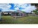 Screened-in pool with surrounding landscaping at 1370 Kenmore St, Port Charlotte, FL 33952
