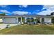 Single-story home with a gray roof, white walls, and blue accents at 1370 Kenmore St, Port Charlotte, FL 33952