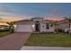 Two-story house with gray exterior, brick driveway, and landscaped lawn at 16138 Highgate St, Port Charlotte, FL 33953
