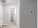 Hallway with laundry room access and wood-look tile flooring at 16138 Highgate St, Port Charlotte, FL 33953