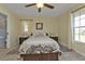 Inviting bedroom with a comfortable bed, ceiling fan, and natural light from two windows at 182 Santarem Cir, Punta Gorda, FL 33983