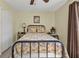 Bedroom with a wrought iron bed, cozy bedding, and side table offers a comfortable space at 182 Santarem Cir, Punta Gorda, FL 33983