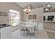Bright dining area with chandelier, next to the kitchen, white table and chairs at 182 Santarem Cir, Punta Gorda, FL 33983