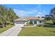 Single-story house with white exterior, two-car garage, and a lush green lawn at 182 Santarem Cir, Punta Gorda, FL 33983
