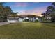 Charming single-story home with a well-manicured lawn and lush landscaping at sunset at 182 Santarem Cir, Punta Gorda, FL 33983