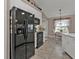 Bright kitchen featuring white cabinets, black appliances, and neutral tile flooring at 182 Santarem Cir, Punta Gorda, FL 33983