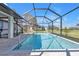 Sparkling pool with a screened-in enclosure, stone pavers, and views of the beautifully landscaped backyard at 182 Santarem Cir, Punta Gorda, FL 33983
