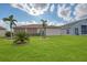 Spacious backyard with lush green grass and palm trees at 24512 Bramhope Ct, Port Charlotte, FL 33980