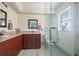 Bathroom with a large glass shower, double vanity, and wood cabinets at 28522 Coco Palm Dr, Punta Gorda, FL 33982