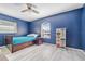 Blue bedroom with twin bed, dresser, and ceiling fan at 28522 Coco Palm Dr, Punta Gorda, FL 33982