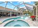 Relaxing pool and spa with covered lanai, outdoor seating, and lush landscaping at 28522 Coco Palm Dr, Punta Gorda, FL 33982