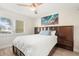 Bedroom with ceiling fan, wood headboard, nightstands, and large window at 433 Cerromar Ln # 441, Venice, FL 34293