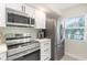 Modern kitchen with stainless steel appliances and light green tile backsplash at 433 Cerromar Ln # 441, Venice, FL 34293