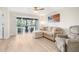 Bright living room with L-shaped sofa, recliner, and sliding glass doors leading to a balcony at 433 Cerromar Ln # 441, Venice, FL 34293