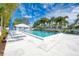 Community pool with lounge chairs, palm trees, and pool house at 433 Cerromar Ln # 441, Venice, FL 34293