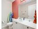 Half bathroom with white vanity, toilet, and red accent wall at 5115 Melbourne St # A206, Punta Gorda, FL 33980