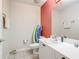 Bathroom with toilet, vanity, and red accent wall at 5115 Melbourne St # A206, Punta Gorda, FL 33980
