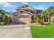 Two-story house with a two-car garage, landscaping, and palm trees at 10043 Winding River Rd, Punta Gorda, FL 33950