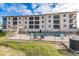 Three-story building with pool and surrounding patio at 1349 Aqui Esta Dr # 125, Punta Gorda, FL 33950