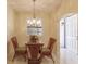 Dining area with glass table, chandelier, and view of entry at 1349 Aqui Esta Dr # 125, Punta Gorda, FL 33950