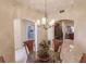Dining area with a chandelier, glass-top table and kitchen view at 1349 Aqui Esta Dr # 125, Punta Gorda, FL 33950