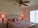 Spacious bedroom with ceiling fan and striped bedding at 1360 Rio De Janeiro Ave # 117, Punta Gorda, FL 33983