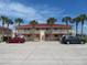 Two-story condo building with red tile roofs, palm trees, and ample parking at 1360 Rio De Janeiro Ave # 117, Punta Gorda, FL 33983