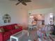 Living room with red sofa, dining table, and kitchen access at 1360 Rio De Janeiro Ave # 117, Punta Gorda, FL 33983