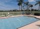 Community pool area with patio furniture and golf course views at 1360 Rio De Janeiro Ave # 117, Punta Gorda, FL 33983
