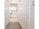 View down a hallway to a bright bathroom with double sinks and walk-in shower at 14009 Black Beauty Dr # 212, Punta Gorda, FL 33955