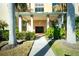 Inviting building entrance with lush landscaping, stately columns, and covered walkway leading to a seating area at 1650 W Marion Ave # 144, Punta Gorda, FL 33950
