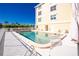 Community pool with surrounding lounge chairs and building view at 1650 W Marion Ave # 144, Punta Gorda, FL 33950