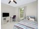 Cozy bedroom featuring a striped comforter, neutral paint and a large window at 2190 Taunt St, Port Charlotte, FL 33948