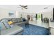 Open-concept living room with modern furnishings, neutral walls, and seamless flow to the kitchen and dining area at 2190 Taunt St, Port Charlotte, FL 33948