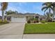 One-story house with a grey exterior, white garage door, and manicured lawn at 2246 Jasmine Way, North Port, FL 34287