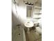 Bathroom features a pedestal sink, tub, and toilet next to some white shelves at 2273 Ednor St, Port Charlotte, FL 33952